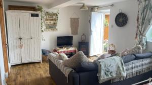 a living room with a blue couch and a tv at Wheelhouse - Grinkle Bell Cottage in Saltburn-by-the-Sea