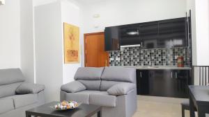 a living room with a couch and a kitchen at Sherryflat Arroyo in Jerez de la Frontera