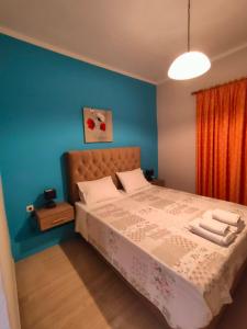 um quarto com uma cama grande e paredes azuis em Dionisos Apts Gouvia by Estia em Corfu Town