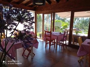 a dining room with a table and chairs and windows at Posada Sel de Breno in Udias