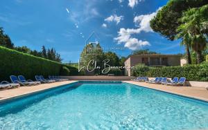 a swimming pool in a villa with chairs and trees at Clapotis des Flots St Tropez XII in Saint-Tropez
