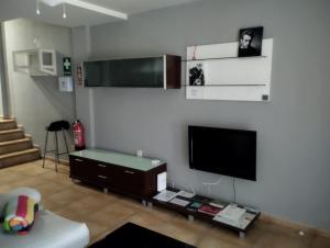 a living room with a flat screen tv on a wall at ALOJAMIENTO LOS DINOSAURIOS in Cuenca