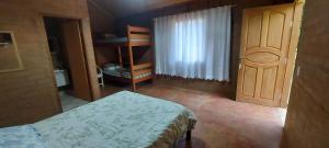 a bedroom with a bed and a wooden cabinet at Tocas do Lago in São Bento do Sapucaí