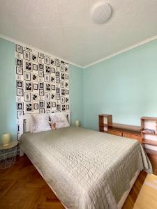 um quarto com uma cama e uma parede com fotografias em Kopaszka Vendégház em Sátoraljaújhely