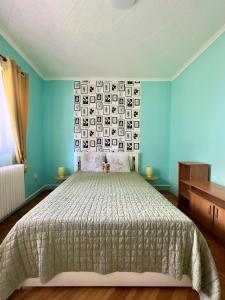 Un dormitorio con una cama y una pared con cuadros. en Kopaszka Vendégház, en Sátoraljaújhely