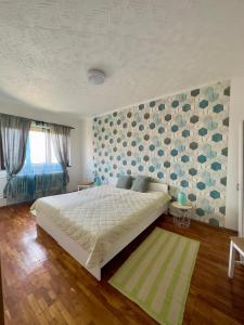 Un dormitorio con una cama grande y una pared con corazones. en Kopaszka Vendégház, en Sátoraljaújhely
