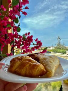 een persoon met een bord gebak op een bord bij Aegean Hospitality in Mykonos-stad