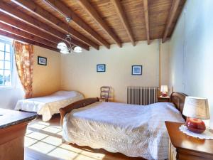 een slaapkamer met 2 bedden en een tafel met een lamp bij Holiday Home Les Chardonnets - BNV400 by Interhome in Biniville