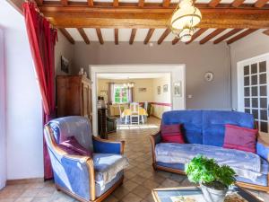 een woonkamer met een blauwe bank en stoelen bij Holiday Home Les Chardonnets - BNV400 by Interhome in Biniville