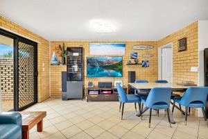 a living room with a table and chairs and a tv at Tee Jays in Sawtell
