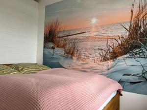 1 dormitorio con una pintura de la playa en Ostsee Ferienwohnung in Sierksdorf - Hansa Park en Sierksdorf