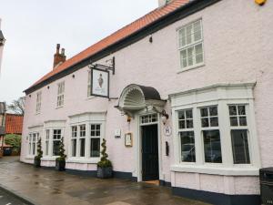 a white building with white windows and a door at Mordon Moor Cottage in Stockton-on-Tees