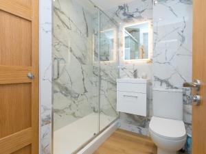 Un baño con inodoro y ducha de cristal. en Millies, en St Ives 30 fotos más