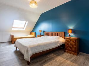 a bedroom with a bed and a blue wall at Holiday Home La Jolie Vague by Interhome in Beaubigny