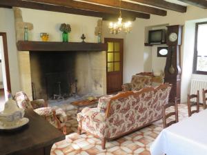sala de estar con chimenea, sofá y sillas en Holiday Home Le Pigeonnier by Interhome, en Jayac
