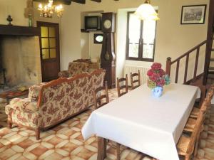 Una sala de estar con una mesa con un jarrón de flores encima. en Holiday Home Le Pigeonnier by Interhome, en Jayac 8 fotos más