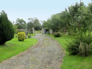 eine Schotterstraße in einem Garten mit Büschen und Bäumen in der Unterkunft Holiday Home Les Lutins - COM400 by Interhome in Commes