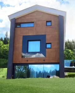 a building with a reflection of the sky in the windows at Chalet Malino - Apartments in Ružomberok
