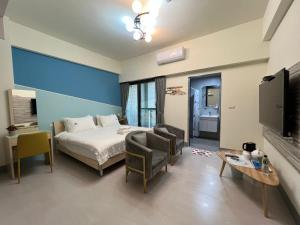 東港的住宿－東津灣旅休閒民宿，一间卧室配有一张床、两把椅子和一台电视