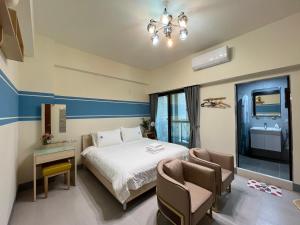 東港的住宿－東津灣旅休閒民宿，一间卧室配有一张床和两把椅子