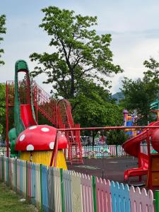 um parque infantil com um escorrega colorido num parque em Apart Central em Orşova