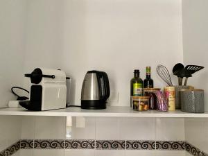 ein Regal mit Kaffeemaschine und Weinflaschen in der Unterkunft Central and Convenient Studio in Monaco in Monte Carlo