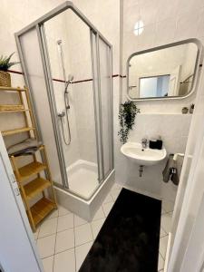 uma casa de banho branca com um chuveiro e um lavatório. em Stilvoller Altbau in zentraler Lage em Dresden