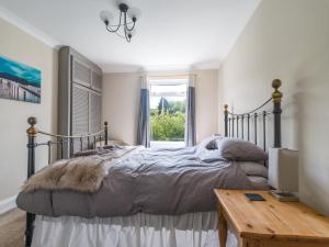 um quarto com uma cama, uma secretária e uma janela em The Hideaway em Morpeth