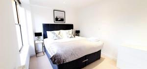 ein Schlafzimmer mit einem großen Bett in einem weißen Raum in der Unterkunft Cliftonville Heights - 2 bed Home away from Home in Northampton