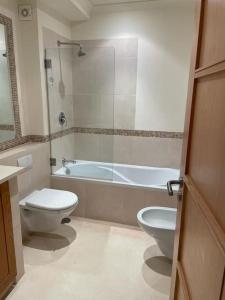 ein Badezimmer mit Toilette und Badewanne in der Unterkunft 2 bed Apartment Palmyra Vila Sol in Quarteira