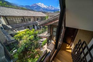 een uitzicht op een gebouw met bergen op de achtergrond bij The Bivou Lijiang in Lijiang