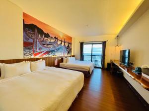 a hotel room with two beds and a television at Taitung Blue Sea Villa in Chenggong