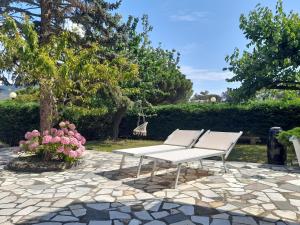 a white picnic table and two chairs on a stone patio at Casa Giardino in Spotorno