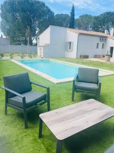 two chairs and a table next to a swimming pool at La Maison d à côté 8 à 10 personnes in Carpentras