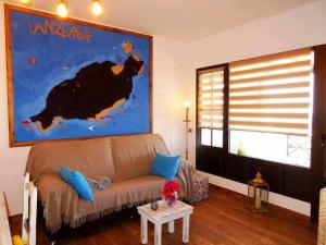 a living room with a couch and a painting on the wall at Apartamento deluxe Betancort in La Asomada