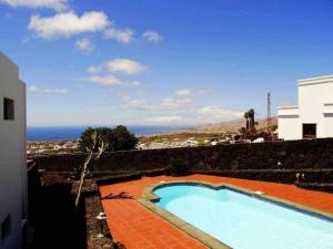 a swimming pool in front of a building at Apartamento deluxe Betancort in La Asomada