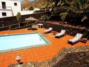 a swimming pool with two lounge chairs and a table at Apartamento deluxe Betancort in La Asomada