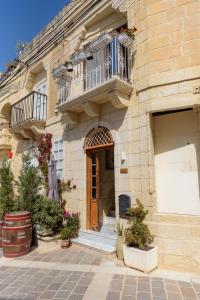 budynek z balkonem i drewnianymi drzwiami w obiekcie Casa Deguara townhouse Rabat Malta w mieście Rabat
