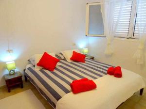 プラヤ・ケマダにあるCasa Descanso con Jacuzzi en Playa Quemadaのベッドルーム1室(赤い枕のベッド1台付)