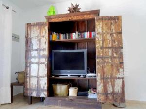 an old wooden book shelf with a television in it at Casa Descanso con Jacuzzi en Playa Quemada in Playa Quemada