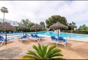 einen Pool mit blauen Stühlen und Sonnenschirmen in der Unterkunft Casa Anyelo in Marbella