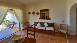 a living room with a couch and a table at Villa Rena Bianca in Baja Sardinia