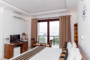a bedroom with a bed and a large window at Centhara Beach Weligama in Weligama