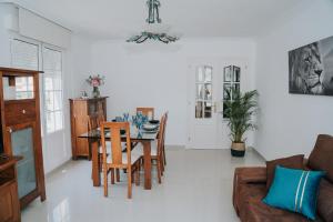a dining room and living room with a table and chairs at Meu Lar in Rianjo