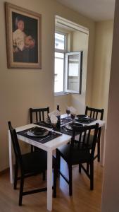 a dining room table with black chairs and a baby picture at Apartamento Anjos in Lisbon +15 photos