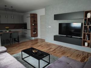 a living room with a couch and a tv and a table at Apartman Plum - SELF CHECK IN, FREE PARKING in Osijek