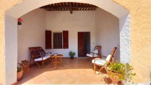 a patio with chairs and a table and an archway at Villa Rena Bianca in Baja Sardinia +20 photos