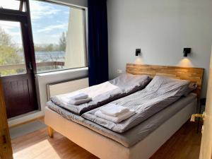 a bed in a room with a large window at Matkráin Apartments in Hveragerði