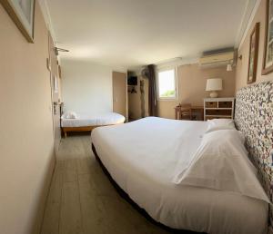 Un dormitorio con una gran cama blanca y una ventana en Contact Hotel LE SUD Montpellier Aéroport Parc Expo Arena, en Mauguio