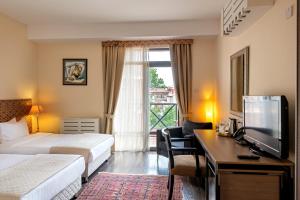 a hotel room with two beds and a desk with a television at GINGER Hotel in Tbilisi City +49 photos